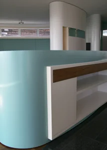 Spezialanfertigung – Sideboard als Oval, farbig lackiert (vorne), passend zur Säulenverkleidung als Schrankelement (hinten)